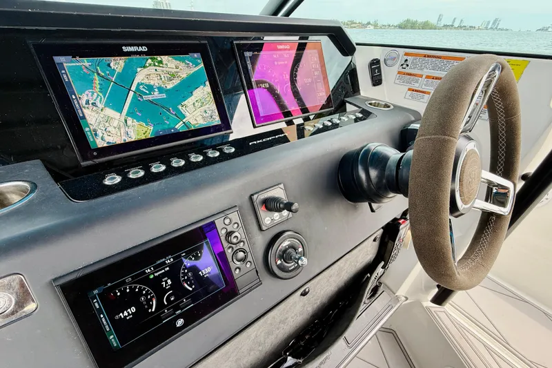 Slide: The Image of 2021 Axopar 37 Sun Top dashboard with navigation screens and steering wheel. - 34