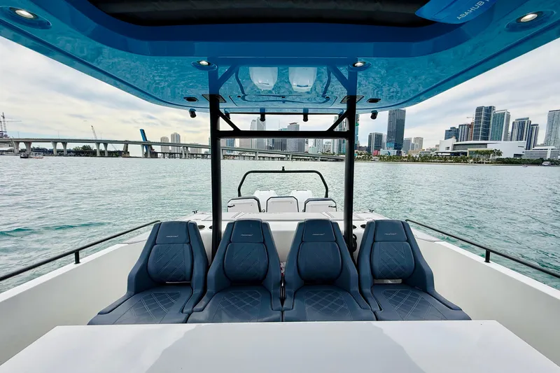 Slide: The Image of 2021 Axopar 37 Sun Top boat with city skyline and water view. - 39