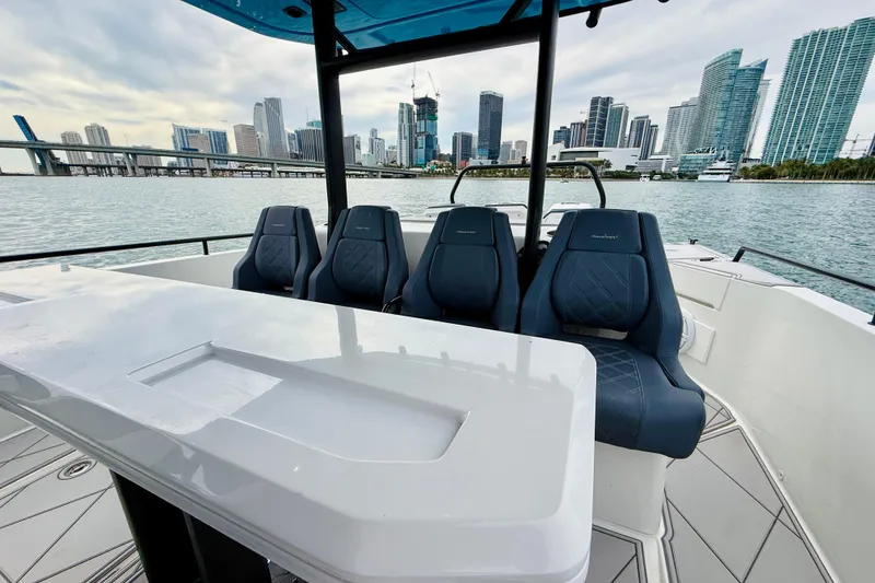 Slide: The Image of 2021 Axopar 37 Sun Top boat interior with city skyline in background. - 41
