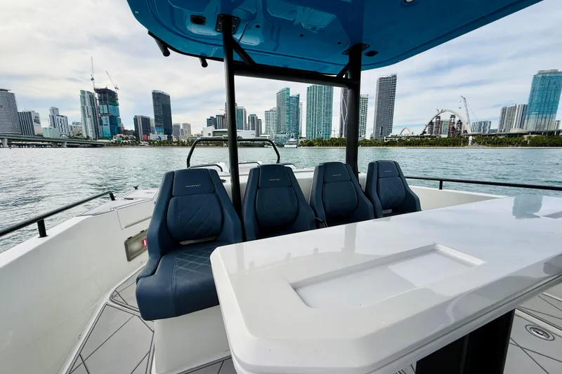 Slide: The Image of 2021 Axopar 37 Sun Top boat with city skyline in the background. - 42