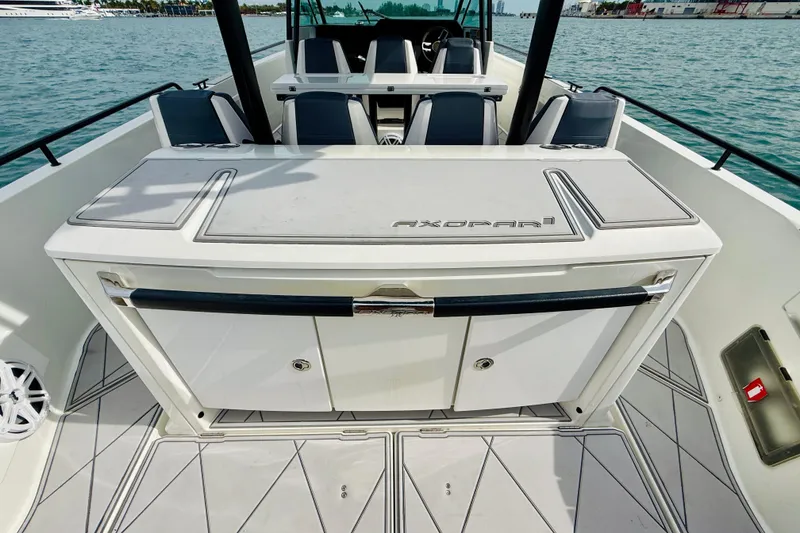 Slide: The Image of 2021 Axopar 37 Sun Top boat interior with seating and storage, on calm water. - 45