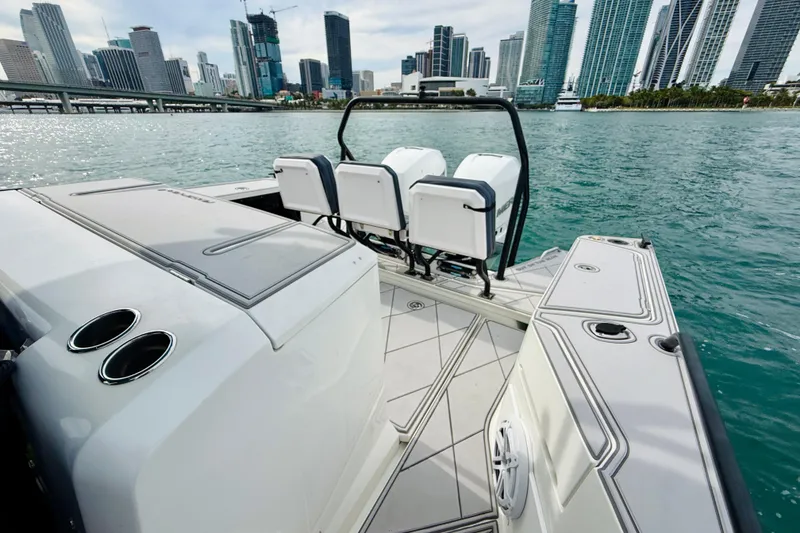 Slide: The Image of 2021 Axopar 37 Sun Top boat with city skyline in the background. - 47
