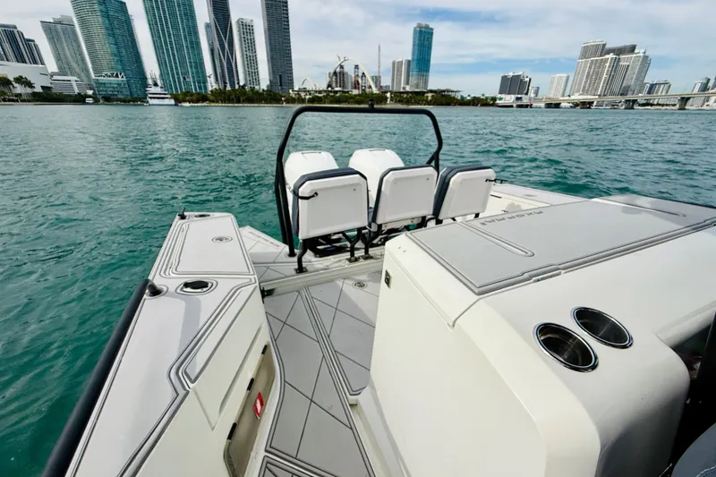 Slide: The Image of 2021 Axopar 37 Sun Top boat with city skyline in the background. - 48