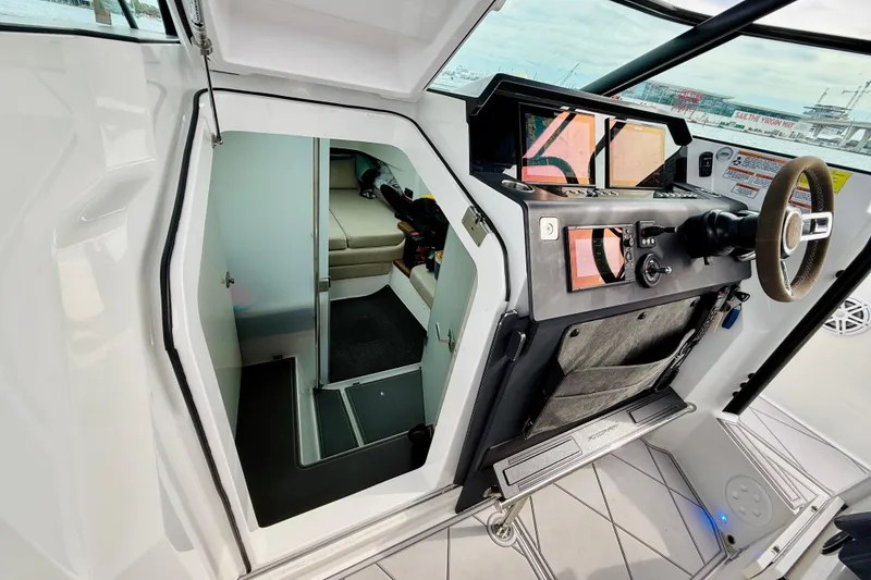 Slide: The Image of 2021 Axopar 37 Sun Top helm with cabin entrance, featuring modern controls and seating. - 52