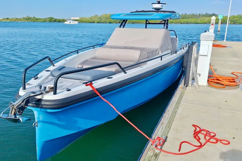 Slide: The Image of 2021 Axopar 37 Sun Top boat docked on clear blue water. - 60