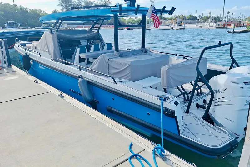 Slide: The Image of 2021 Axopar 37 Sun Top boat docked, featuring blue hull and covered seating. - 61