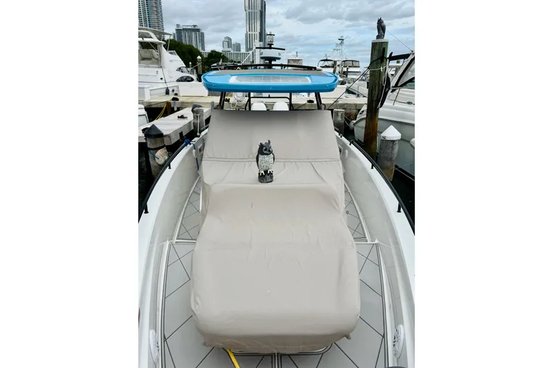 Slide: The Image of 2023 Axopar 37 Sun Top boat with covered seating at a marina. - 63