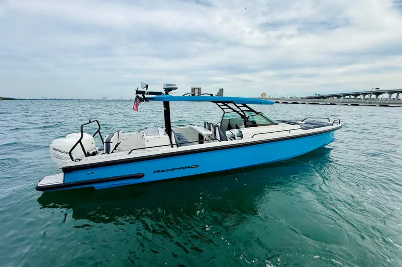Slide: The Image of 2021 Axopar 37 Sun Top boat on water, featuring sleek design and vibrant blue color. - 7