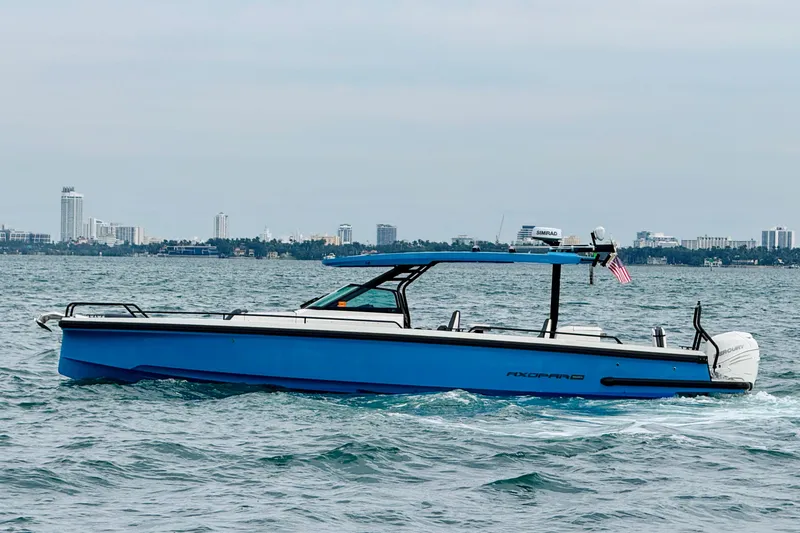 Slide: The Image of 2021 Axopar 37 Sun Top boat cruising on water with city skyline in background. - 8