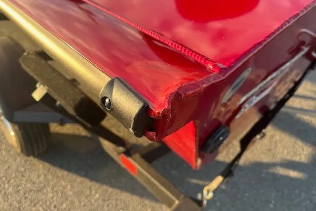 Slide: The Image of Damaged rear corner of 2025 Tracker Pro Team 175 boat in sunlight. - 12