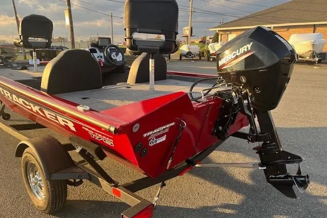 Slide: The Image of 2025 Tracker Pro Team 175 boat with Mercury engine, parked outdoors in sunlight. - 13