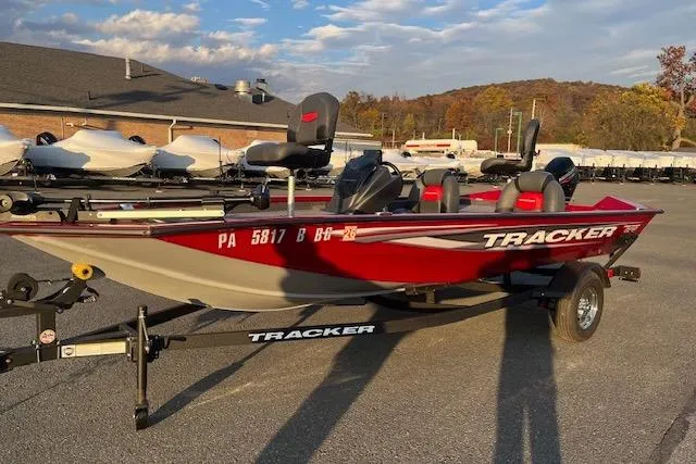 Slide: The Image of 2025 Tracker Pro Team 175 boat on trailer, parked outdoors under a clear sky. - 15