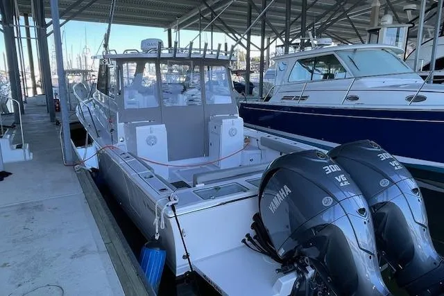 The Image of 2023 NorthCoast 315 boat docked in a marina under a covered area. - 0