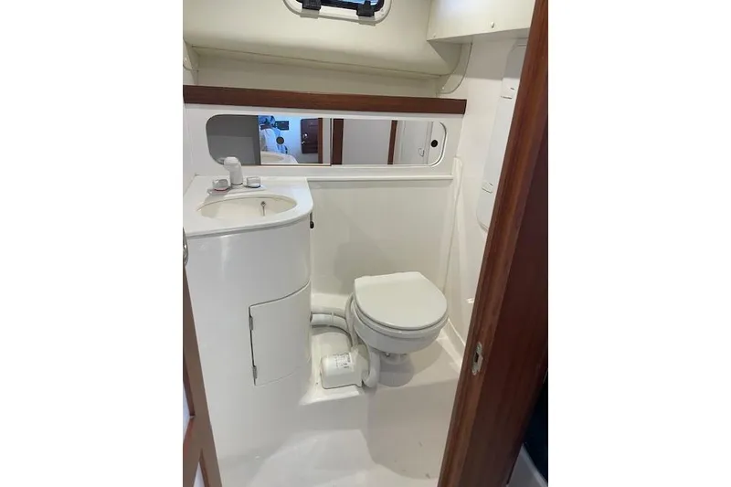 Slide: The Image of 2023 NorthCoast 315 boat bathroom with sink, toilet, and mirror. - 43
