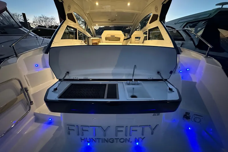 Slide: The Image of 2019 Beneteau Gran Turismo 40 yacht with outdoor kitchen, illuminated at dusk. - 10
