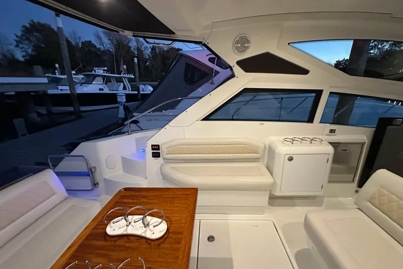 Slide: The Image of 2019 Beneteau Gran Turismo 40 interior with seating and table, docked at marina. - 17