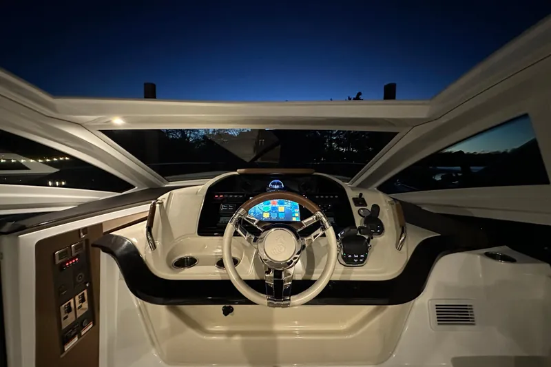 Slide: The Image of 2019 Beneteau Gran Turismo 40 helm at dusk, featuring modern controls and illuminated dashboard. - 22