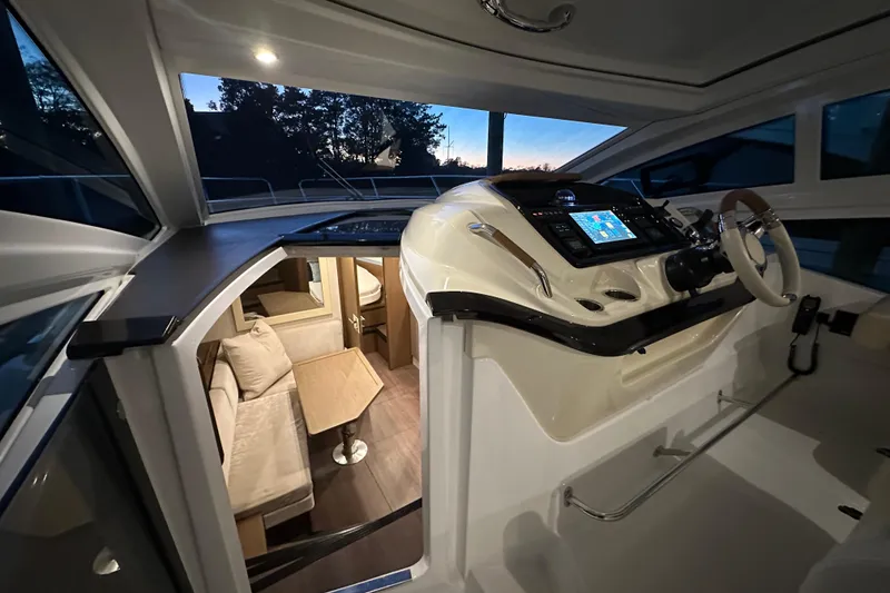 Slide: The Image of 2019 Beneteau Gran Turismo 40 interior with helm, seating, and navigation equipment at dusk. - 24