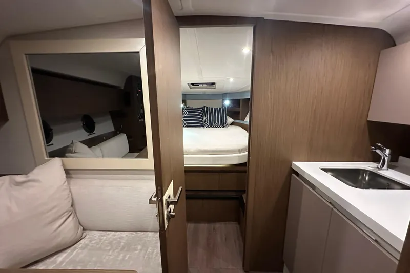Slide: The Image of Interior of 2019 Beneteau Gran Turismo 40 yacht, featuring cozy cabin and kitchenette. - 28