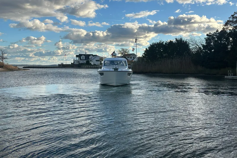 Slide: The Image of 2019 Beneteau Gran Turismo 40 yacht cruising on a serene waterway under a partly cloudy sky. - 3