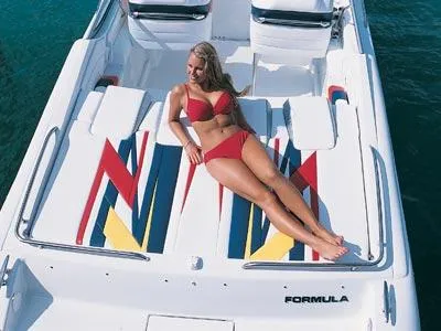 Slide: The Image of 2004 Formula 292 FASTech boat cruising in a marina with yachts and buildings in the background. - 2