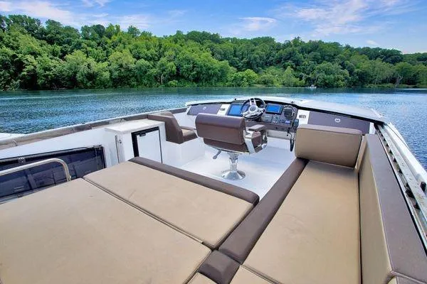 Slide: The Image of Luxurious 2017 Galeon 560 Sky yacht interior with plush seating, overlooking serene lake and lush greenery. - 35