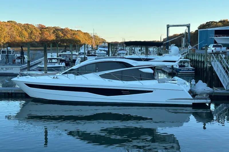 Slide: The Image of 2017 Galeon 560 Sky yacht docked in a marina with autumn trees in the background. - 38