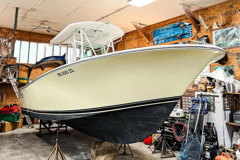 The Image of 2009 Blue Fin 240 Islander boat in a garage, surrounded by fishing gear and decor. - 0