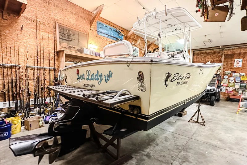 Slide: The Image of 2009 Blue Fin 240 Islander boat in garage, surrounded by fishing gear. - 11