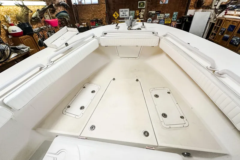 Slide: The Image of 2009 Blue Fin 240 Islander boat interior with white seating and storage compartments. - 14