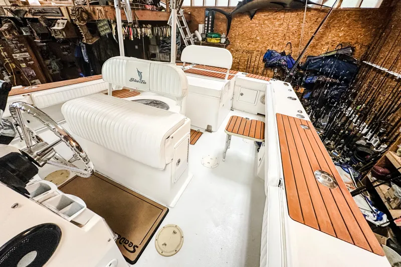 Slide: The Image of 2009 Blue Fin 240 Islander boat interior with wood accents and fishing gear. - 16