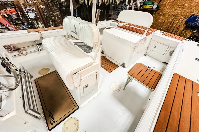 Slide: The Image of Interior of 2009 Blue Fin 240 Islander boat with white seating and wood accents. - 17