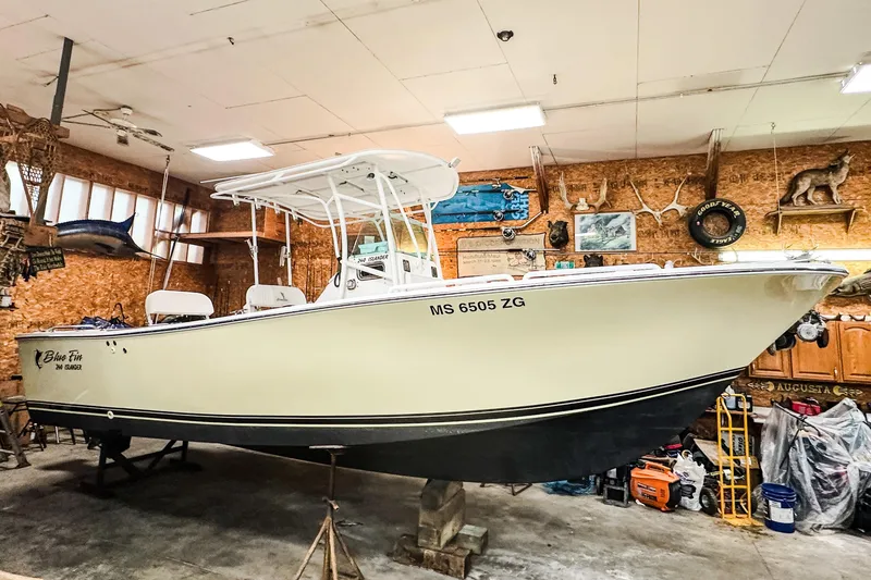 Slide: The Image of 2009 Blue Fin 240 Islander boat in a garage with nautical decor. - 2