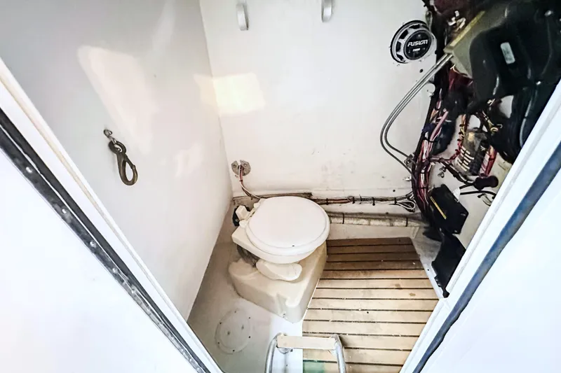 Slide: The Image of 2009 Blue Fin 240 Islander boat interior with toilet and wiring. - 25