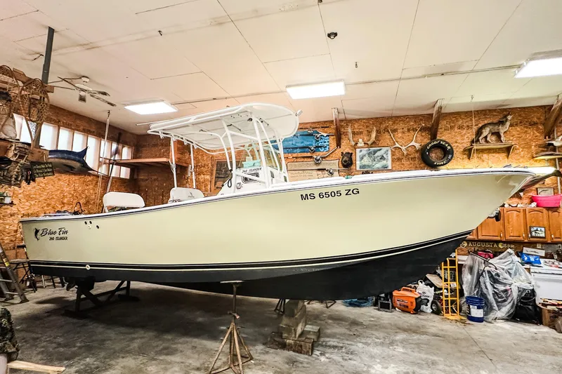 Slide: The Image of 2009 Blue Fin 240 Islander boat in a rustic garage setting. - 3