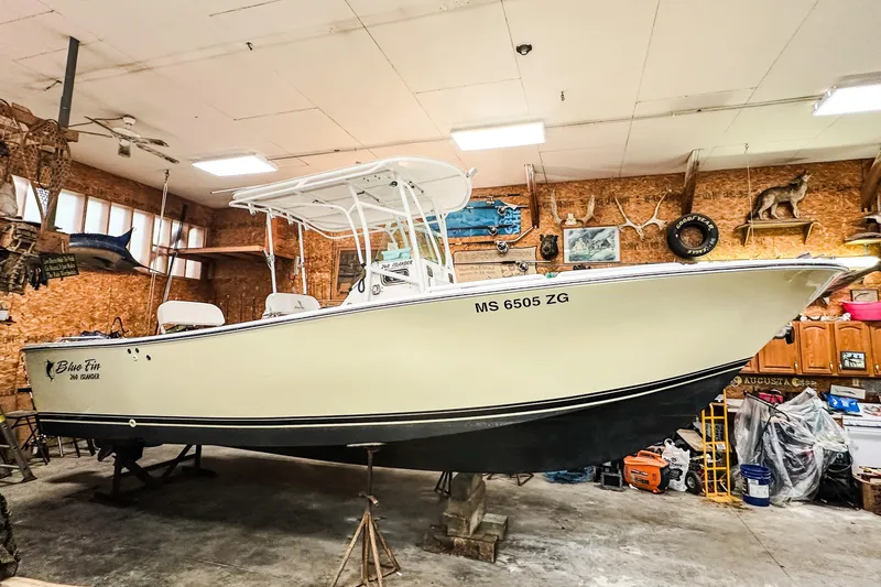 Slide: The Image of 2009 Blue Fin 240 Islander boat in a garage, surrounded by various tools and decorations. - 4