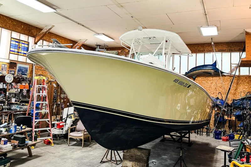 Slide: The Image of 2009 Blue Fin 240 Islander boat in a workshop, surrounded by tools and equipment. - 5