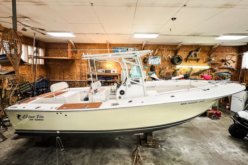 Slide: The Image of 2009 Blue Fin 240 Islander boat in a garage with rustic decor. - 9