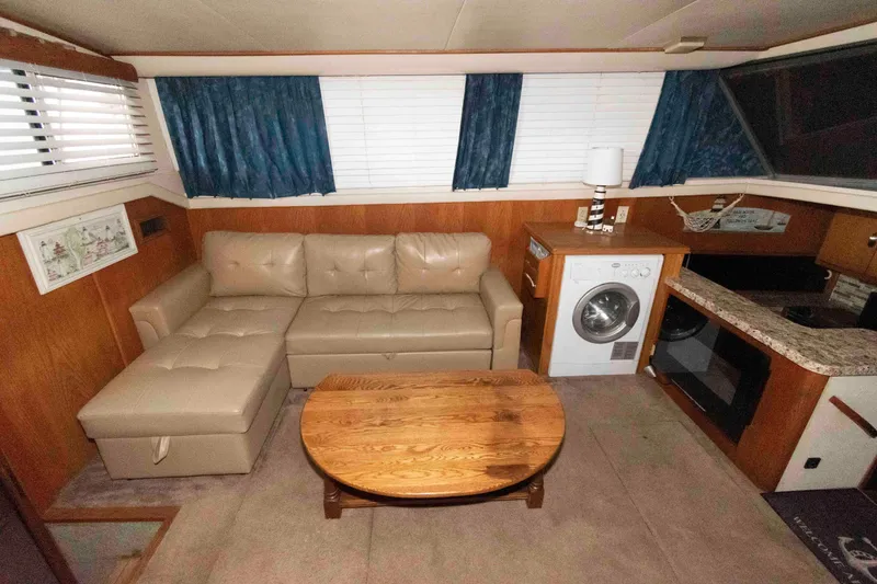 Slide: The Image of 1990 Silverton 40 Aft Cabin interior with sofa, table, washer, and kitchenette. - 10