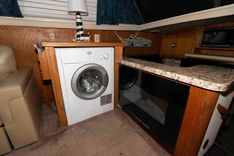 Slide: The Image of 1990 Silverton 40 Aft Cabin interior with washer, countertop, and wooden cabinetry. - 11