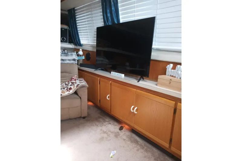 Slide: The Image of Interior of 1990 Silverton 40 Aft Cabin with TV and wooden cabinets. - 12