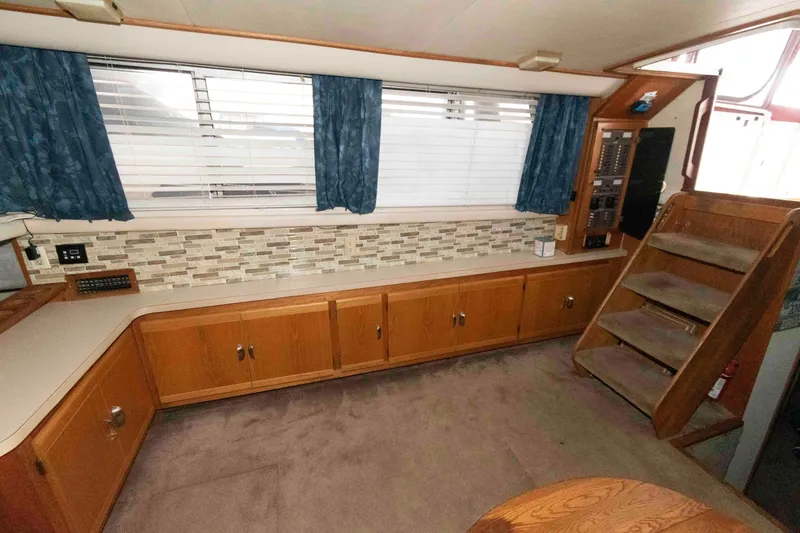 Slide: The Image of 1990 Silverton 40 Aft Cabin interior with wood cabinetry, carpet, and stairs. - 13