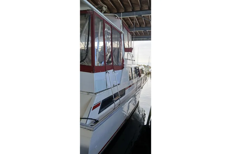Slide: The Image of 1990 Silverton 40 Aft Cabin yacht docked in a covered marina. - 2