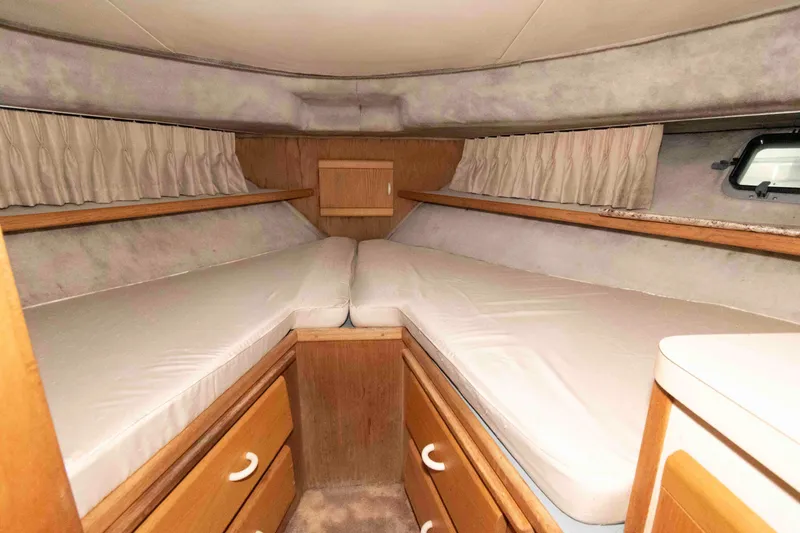 Slide: The Image of 1990 Silverton 40 Aft Cabin interior with twin beds and wooden storage drawers. - 21