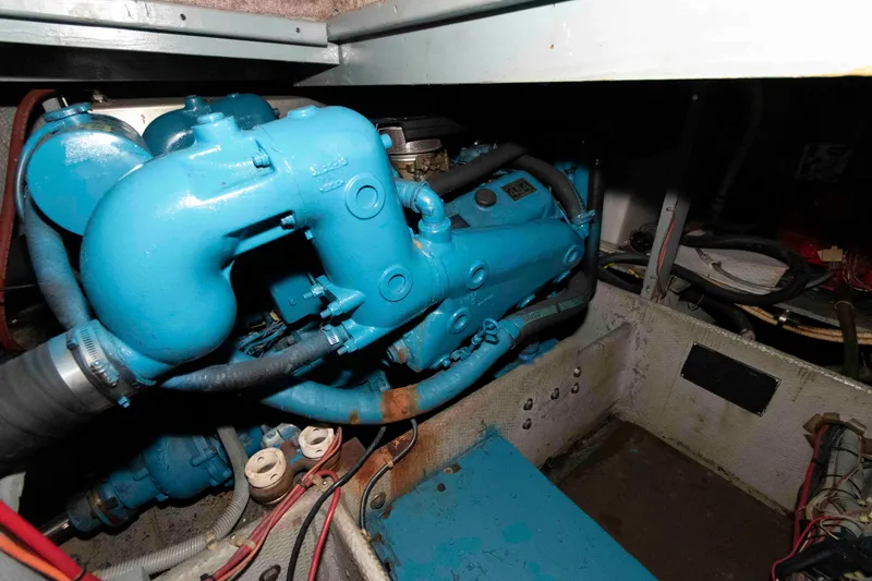 Slide: The Image of Engine compartment of a 1990 Silverton 40 Aft Cabin boat, featuring a blue engine. - 25