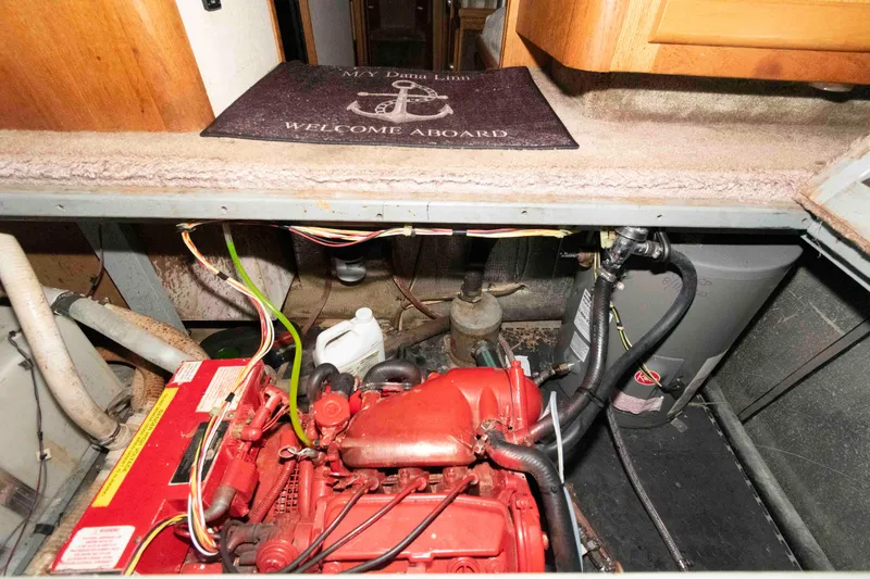 Slide: The Image of Engine room of 1990 Silverton 40 Aft Cabin with red engine and welcome mat. - 27