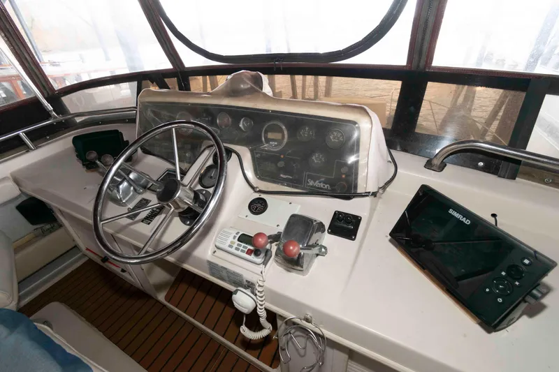 Slide: The Image of 1990 Silverton 40 Aft Cabin helm with steering wheel and navigation equipment. - 8