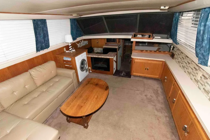 Slide: The Image of Interior of 1990 Silverton 40 Aft Cabin yacht with sofa, table, and kitchenette. - 9