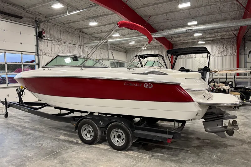 Slide: The Image of 2006 Cobalt 24SX boat with red and white design on trailer in indoor storage. - 4