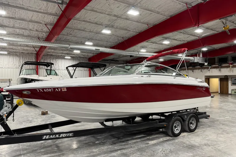Slide: The Image of 2006 Cobalt 24SX boat with red and white exterior on trailer in indoor storage. - 9